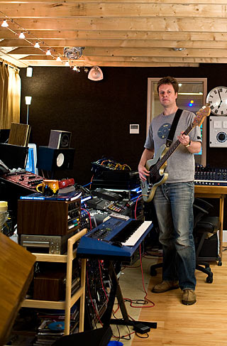 george shilling playing guitar in his music studio