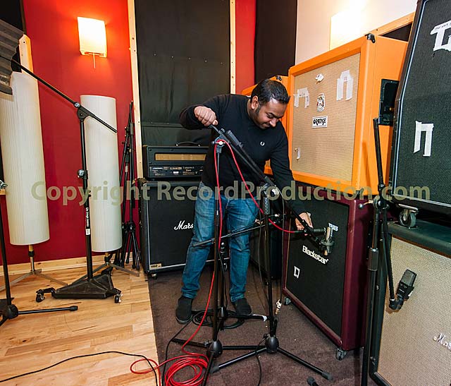 Longwave romesh in the studio setting up microphones on guitar cabs